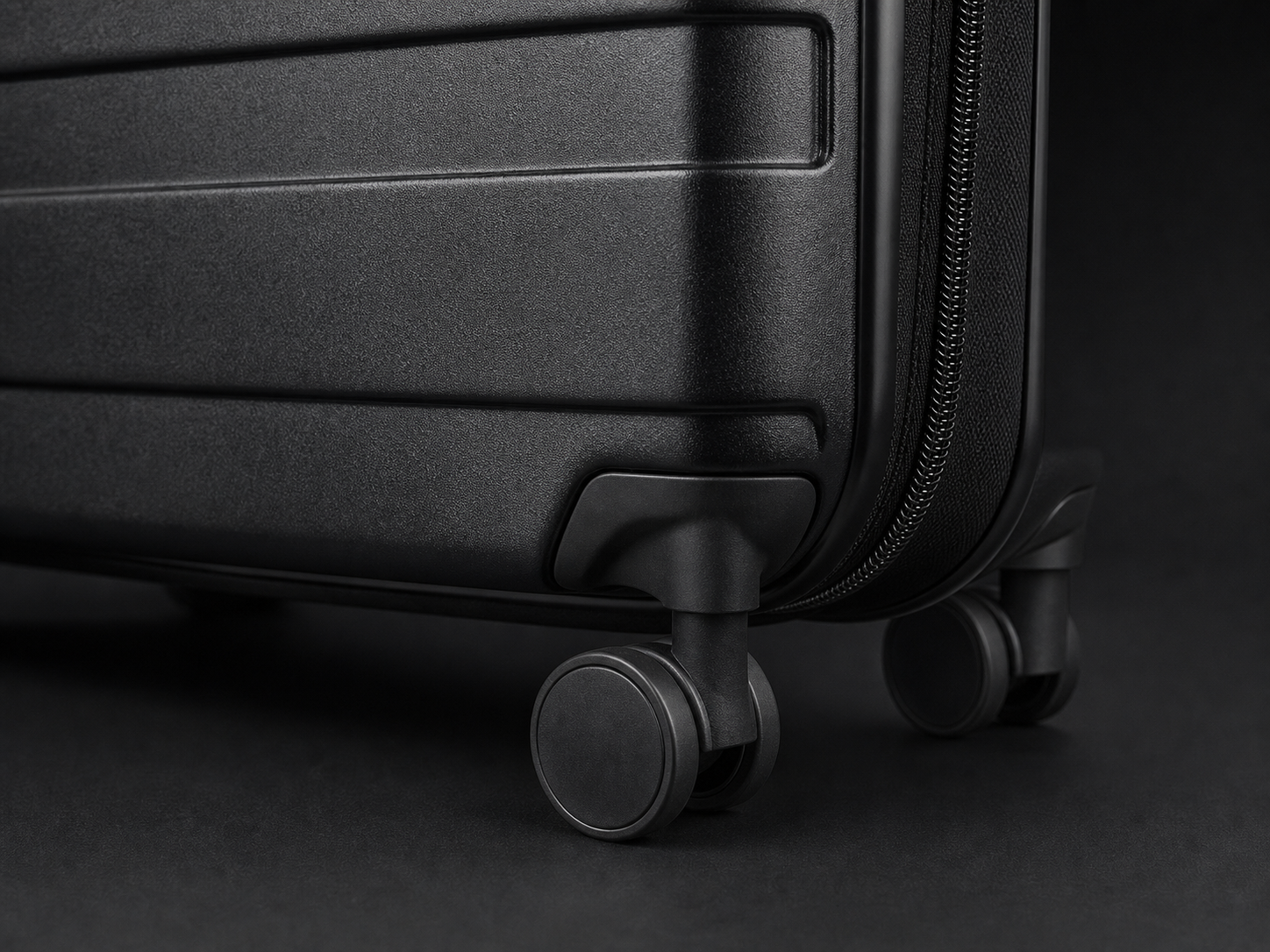 Black wheeled suitcase with textured finish, zipper closure, and side handles