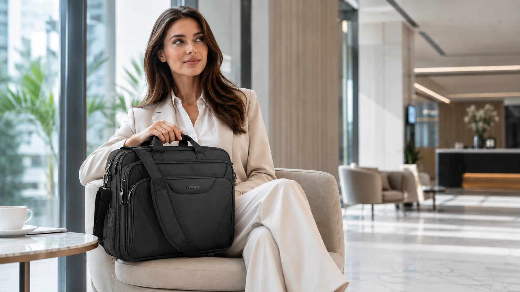 Woman carrying a KROSER black laptop briefcase in a modern business lounge