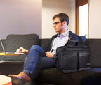 Black business laptop briefcase carried by a man while seated on a couch