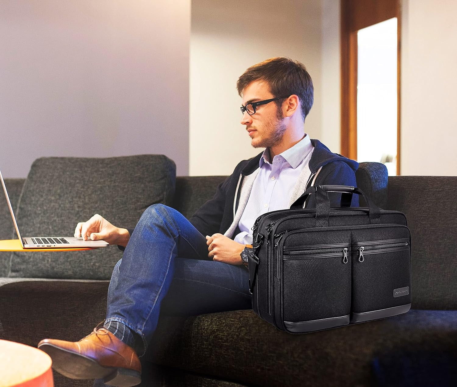 Black business laptop briefcase carried by a man while seated on a couch