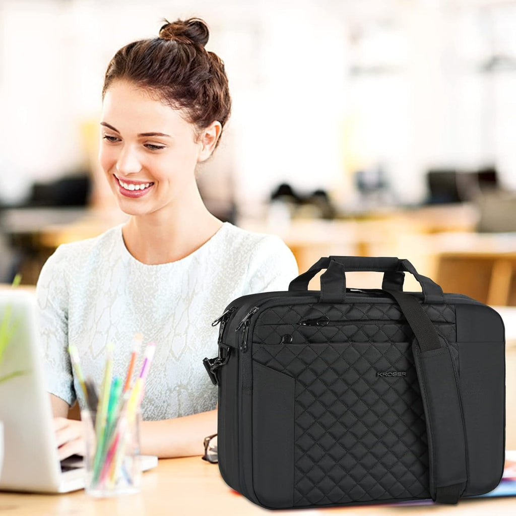 Black quilted 17-inch laptop briefcase with top handle and side strap on desk