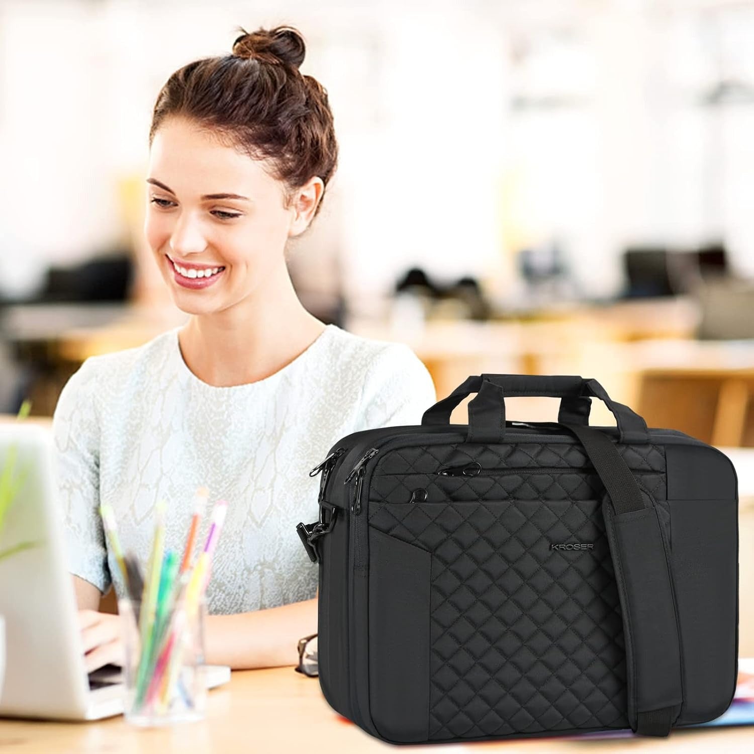 Black quilted laptop briefcase with front pocket, top handle, and shoulder strap