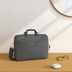 Gray laptop briefcase with top handle and side shoulder strap, zippered compartments