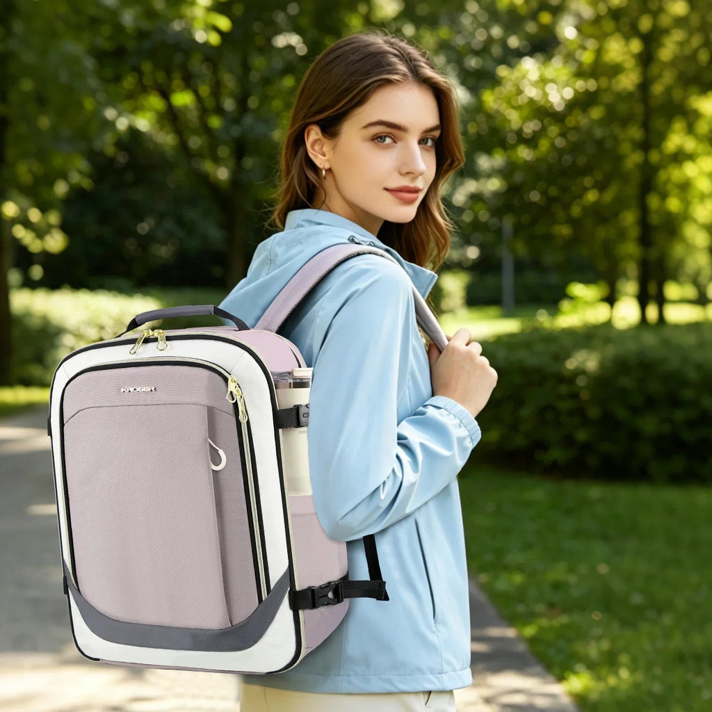 Dusty pink women’s travel backpack worn on shoulders, front zip pocket and gold accents
